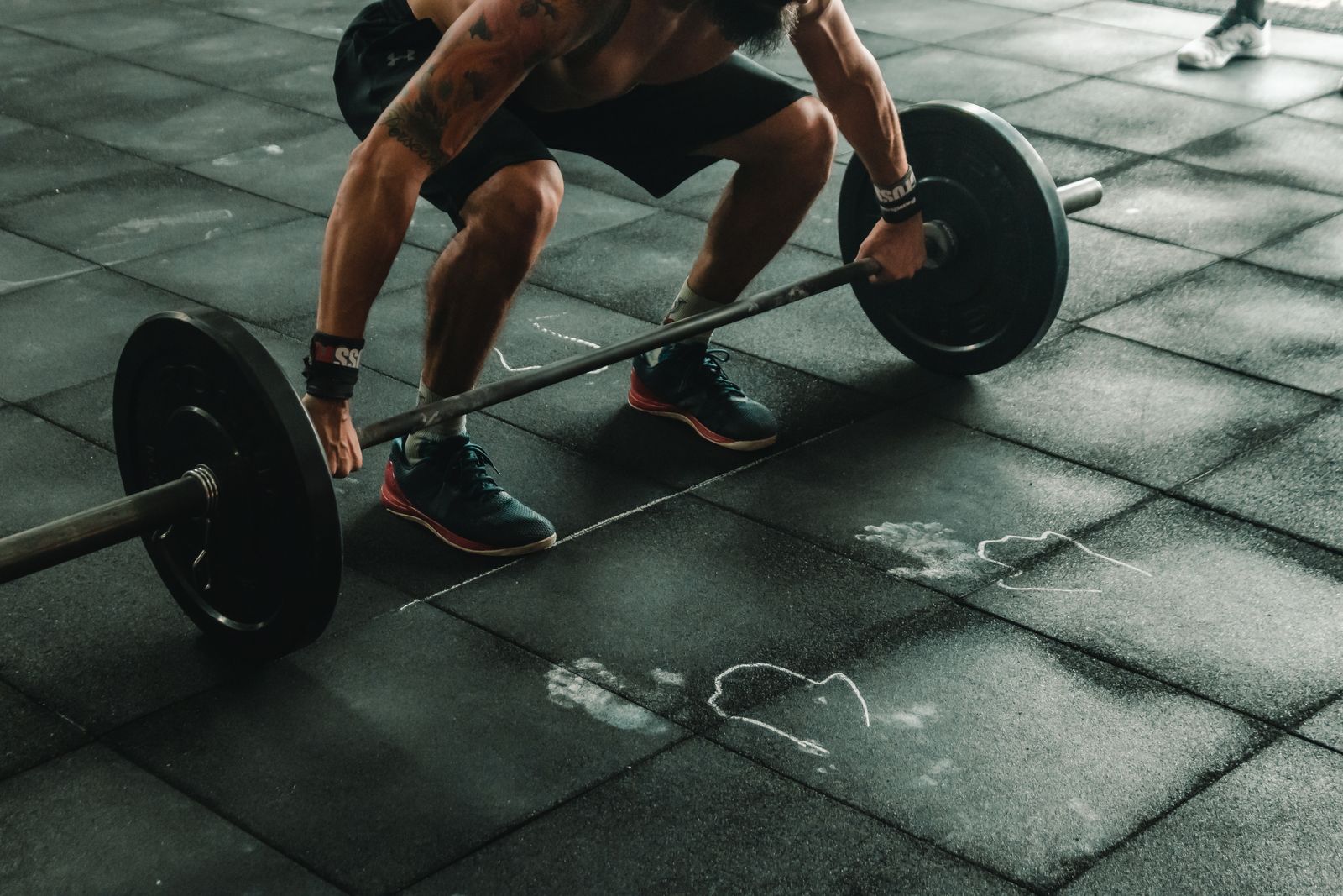 Chalk on the barbell before a deadlift set — TYAGA club